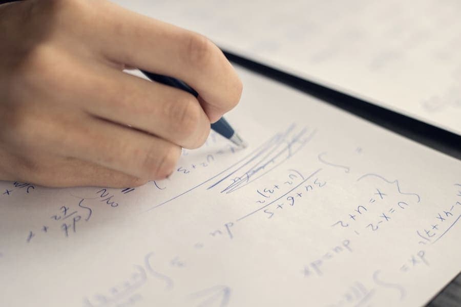 Handwritten equations worked out on paper